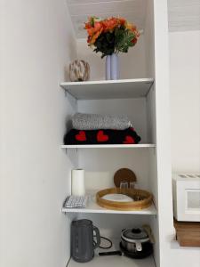 ein Küchenregal mit Spüle und einer Vase mit Blumen in der Unterkunft Chez Carla in Sisteron + 9 Fotos