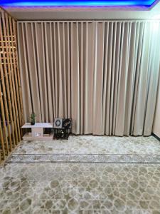 een kamer met een groot gordijn en een tafel met een stoel bij مرايا بارك in Al Mikhlaf