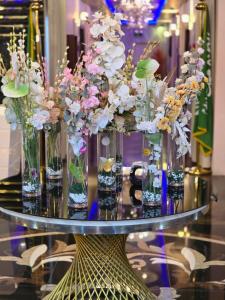 een tafel met vazen gevuld met bloemen erop bij مرايا بارك in Al Mikhlaf
