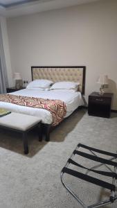 een slaapkamer met twee bedden met witte lakens en kussens bij مرايا بارك in Al Mikhlaf