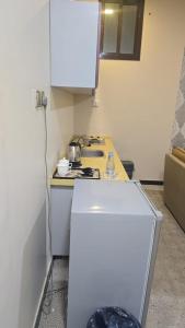 een keuken met een witte koelkast en een fornuis bij مرايا بارك in Al Mikhlaf +2 foto's