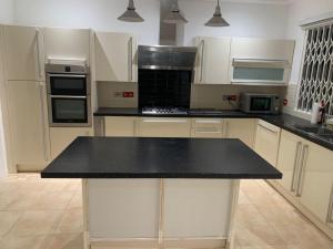 eine Küche mit weißen Schränken und einer schwarzen Arbeitsplatte in der Unterkunft Haven Seven Property - 1 bedroom, 2 bedroom, 3 bedroom Executive options in Takoradi