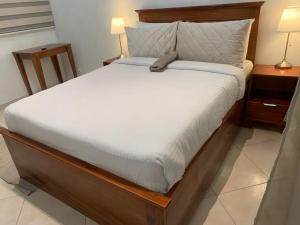 ein Schlafzimmer mit einem Bett mit Holzrahmen und einem Bett sidx sidx in der Unterkunft Haven Seven Property - 1 bedroom, 2 bedroom, 3 bedroom Executive options in Takoradi