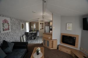 un salon avec un canapé et une télévision dans l'établissement No16 Caravan, home from home, à Angus