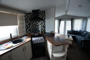 Il dispose d'une cuisine et d'un salon avec un évier et un canapé. dans l'établissement No16 Caravan, home from home, à Angus
