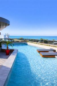 een zwembad met de oceaan op de achtergrond bij W Tambaú Apart Hotel in João Pessoa