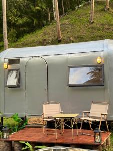 two chairs and a table in front of a trailer at Anora Eco-Resort Siquijor in Lazi