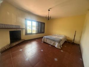 een slaapkamer met een bed en een open haard bij Casa de Campo in Minas