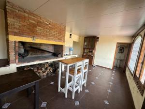 een keuken met een tafel en een stenen open haard bij Casa de Campo in Minas