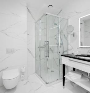 een badkamer met een douche, een toilet en een wastafel bij Hotel grand Park in Szczecin