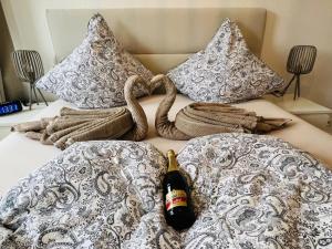 a bottle of beer on a bed with blankets and pillows at Marktblick in Esens
