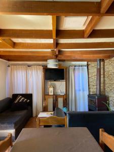 een woonkamer met een bank en een tv bij Cabaña sector centro Villarrica in Villarrica