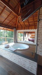 a large bathroom with a large tub in a room at Chalés Descanso na Serra in Monte Verde