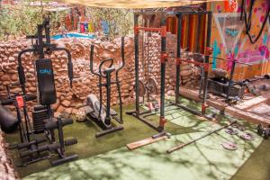 a gym with exercise equipment in front of a wall at Casa Voyage Hostel in San Pedro de Atacama
