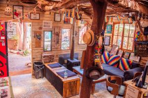 a living room in a log cabin with a tree at Casa Voyage Hostel in San Pedro de Atacama +85 photos