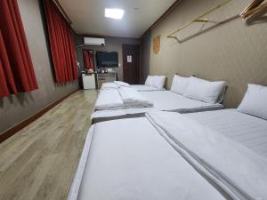 eine Reihe von Betten in einem Zimmer in der Unterkunft 귀빈모텔 in Donghae