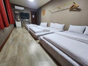 eine Reihe von Betten in einem Hotelzimmer in der Unterkunft 귀빈모텔 in Donghae