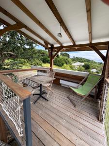 a patio with a table and chairs on a deck at La Kaban in Le Vauclin