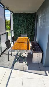 a picnic table and chairs on a balcony with a green wall at Vue Parlement Européen - Grande terrasse au calme - Tram à 2 min - Parking in Strasbourg