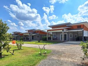 une rangée de maisons modulaires sur une pelouse dans l'établissement บ้านน้ำผึ้งโฮมสเตย์, à Suan Phueng