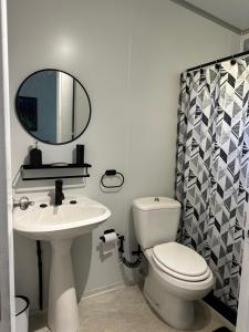 een badkamer met een toilet, een wastafel en een spiegel bij Monoambiente de playa in José Ignacio