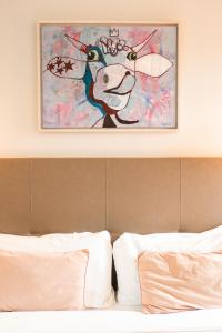 een schilderij van een koe boven een bed bij Benaco36 in Torri del Benaco
