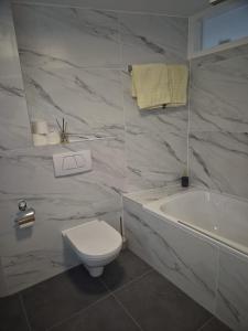 een witte badkamer met een toilet, een bad en een wastafel bij Haus Orta in Zermatt +69 foto's
