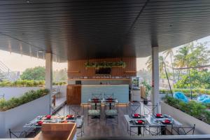 an outdoor kitchen and dining area with tables and chairs at Mikayla Cove in Negombo