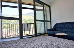 a bedroom with a blue couch and a large window at Studio, centre La Bresse in La Bresse