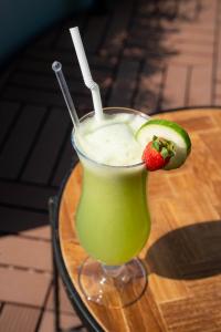a green drink with a strawberry and a straw at Mikayla Cove in Negombo