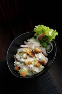 a black bowl of food with a salad in it at Mikayla Cove in Negombo +36 photos