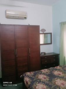 a bedroom with a wooden cabinet and a bed at Puthooram Veedu in Kannur +7 photos