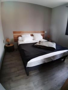 a bedroom with a bed with black sheets and white pillows at Location proche Sarlat in Prats-de-Carlux