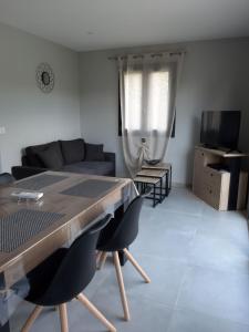 a living room with a table and a couch at Location proche Sarlat in Prats-de-Carlux