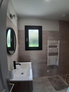 a bathroom with a sink and a mirror and a window at Location proche Sarlat in Prats-de-Carlux