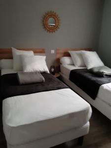 two beds in a room with a mirror on the wall at Location proche Sarlat in Prats-de-Carlux