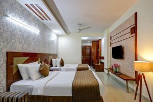 une chambre d'hôtel avec deux lits et une télévision dans l'établissement Hotel B Stays, à Gurgaon 49 autres photos