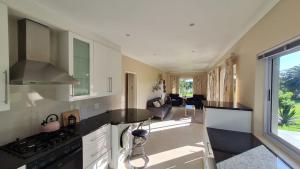 a kitchen with a stove top oven next to a living room at Flanders South Cottage in Gqeberha