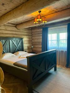 een slaapkamer met een groot bed met een houten plafond bij Amber Hills Romania in Braşov