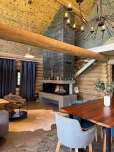 een eetkamer met een tafel en een open haard bij Amber Hills Romania in Braşov