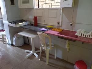 a toy kitchen with a pink counter and a chair at Kitnet Mobiliada in São Luís