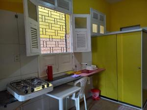 a kitchen with a stove and a sink and a window at Kitnet Mobiliada in São Luís