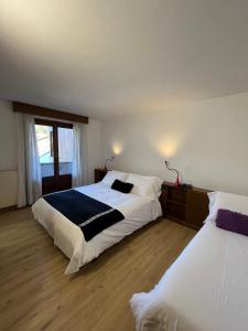 een slaapkamer met twee bedden en een raam bij Hotel Alle Tre Baite in Santa Caterina Valfurva