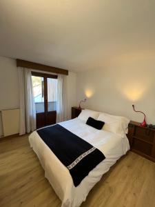 een slaapkamer met een groot bed met witte en zwarte lakens bij Hotel Alle Tre Baite in Santa Caterina Valfurva