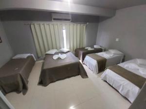 een hotelkamer met twee bedden en een raam bij Hotel Amazonas in Cacoal