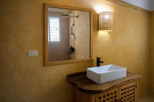 a bathroom with a white sink and a mirror at Casa los Mangos Private pool 150 m from the beach in Las Galeras
