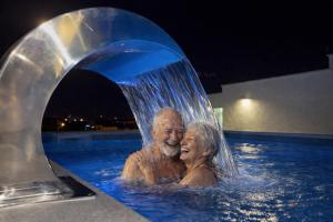 een man en een vrouw in een zwembad bij Apartments Maritea in Vodice