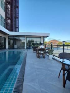 a man sitting on a patio next to a swimming pool at ST Central Hotel, Pakse in Pakse