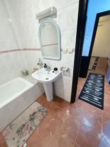 een badkamer met een wastafel, een bad en een spiegel bij CHY dreams in Cabo Negro