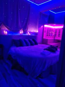 a bedroom with a bed with purple lights on it at Tecaia Secret Luxury Suite in Formia